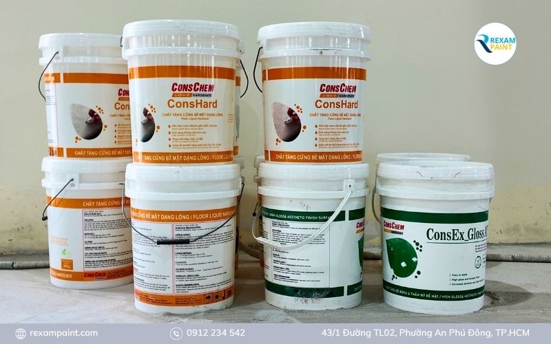Các can hóa chất tăng cứng và phủ bóng sàn bê tông đặt cạnh mặt sàn đã mài