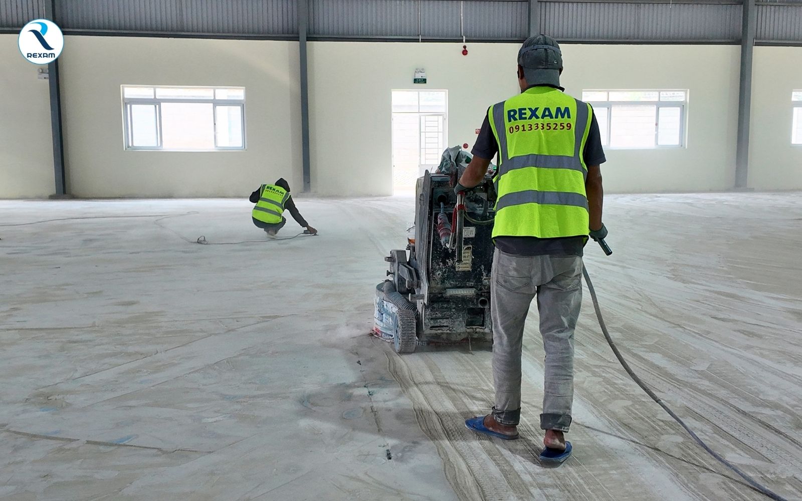 Máy mài sàn nhiều đĩa đang mài nền bê tông trong kho hàng